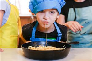 Young chef slurpping spaghetti